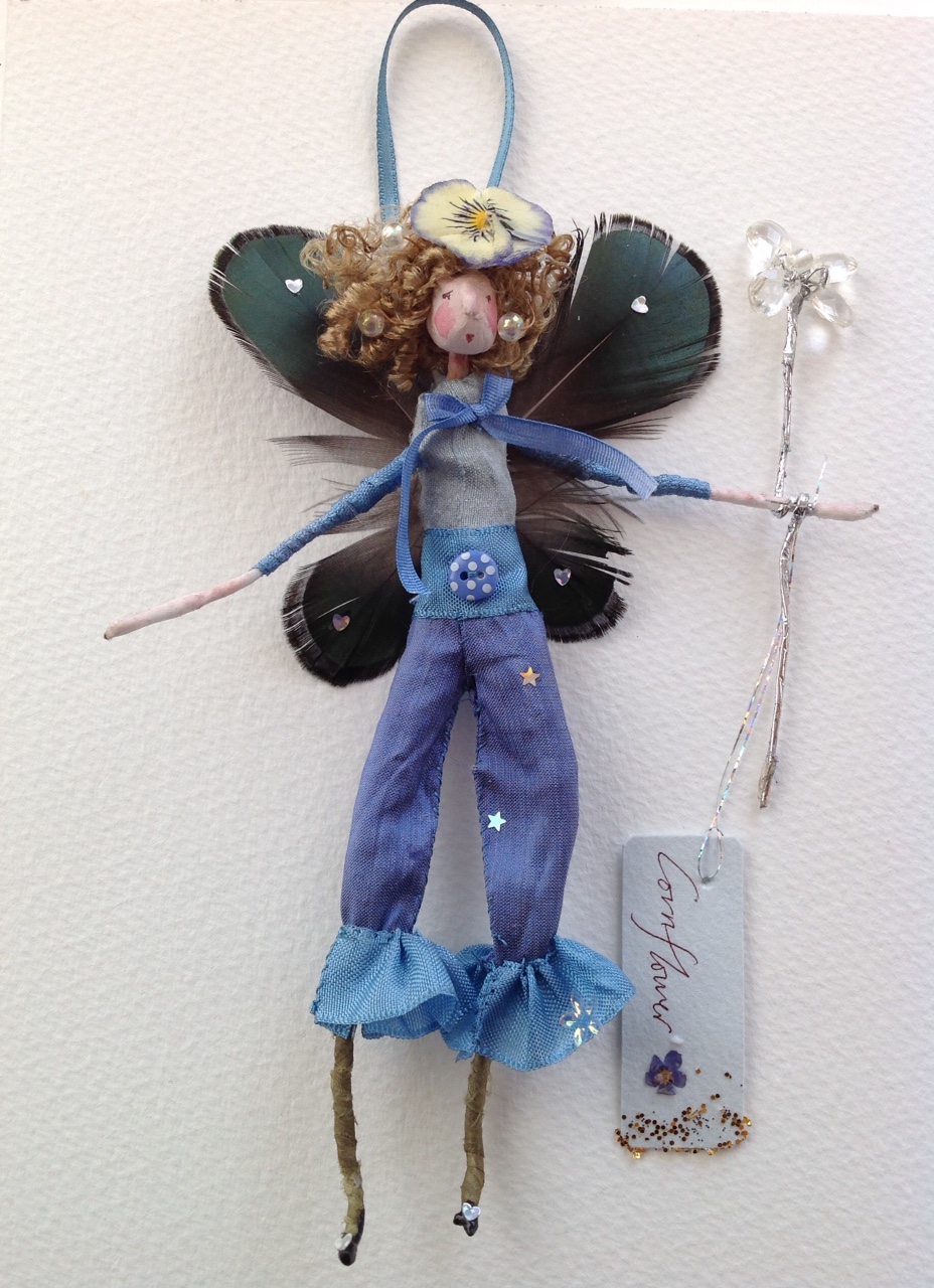 CORNFLOWER A 14cm fairy dressed in silk with peacock feather wings and a dried pansy headdress. £25 plus £3.50 p&p.