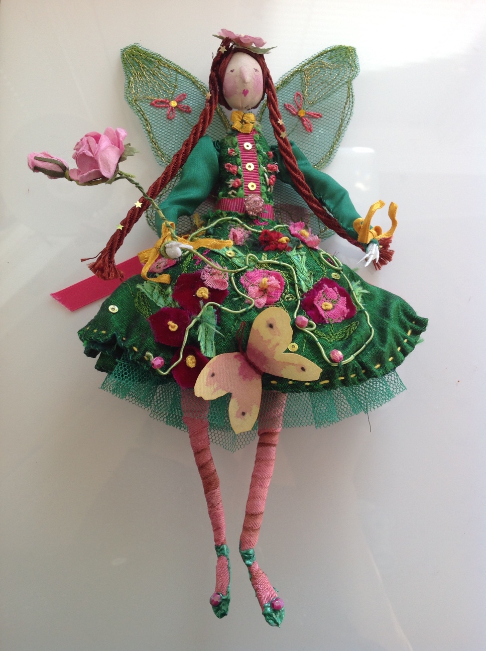 GARDENIA A 22cm fairy. She is wearing a silk dress embroidered with flowers, bows and a silk butterfly. She is embellished with sequins and jewels and carrying a paper rose wand. her wings are stiff net and embodied with gold thread. She comes in an organza bag with a hand painted name tag. £ 50 plus £3.50 p&p.
