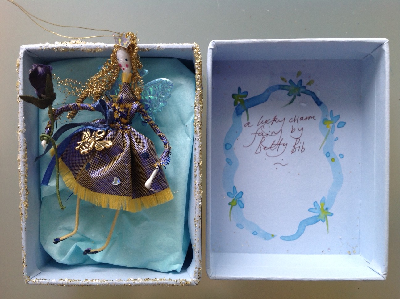 LUCKY CHARM FAIRY A 9cm fairy in a box with a lucky bee charm at her waist. She has a shot lame` dress and has a paper rose wand. £20 plus £3.50 p&p