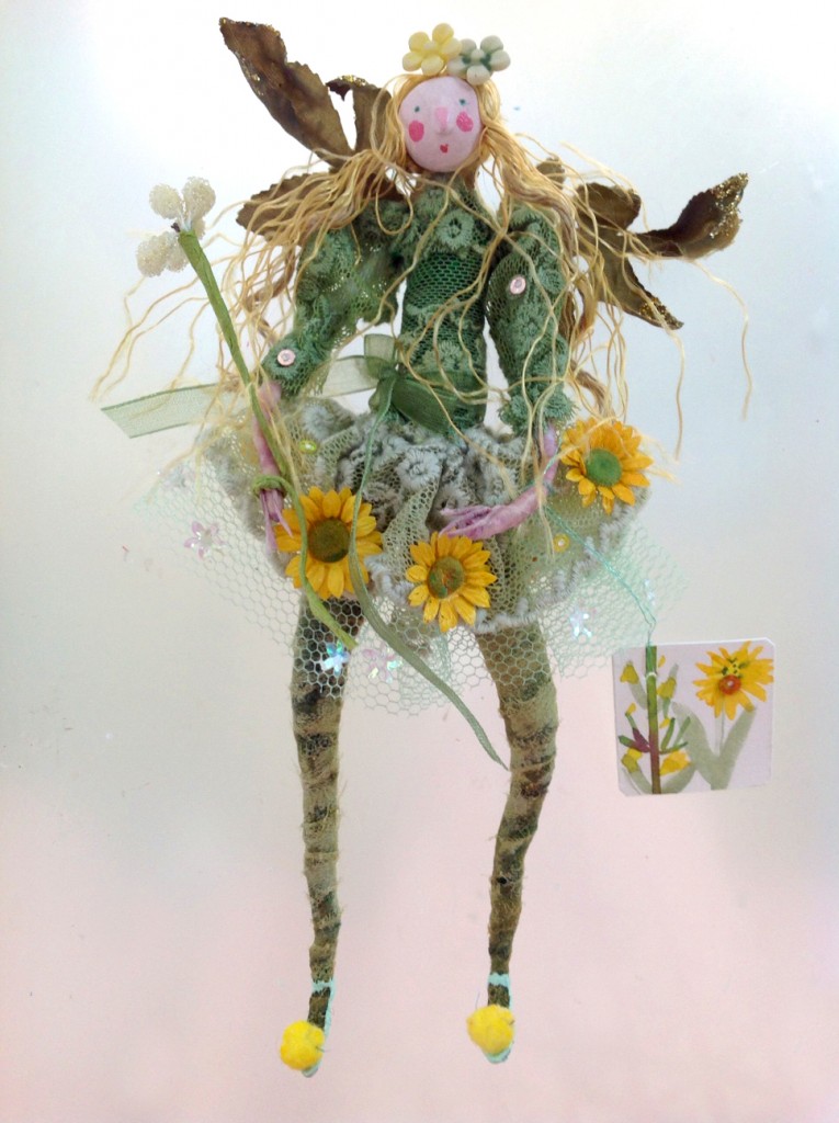 DAISY A 16cm high fairy with a paper clay head. She is wearing a lace and net dress embellished with coated paper daisies and sparkles. She has pom-pom slippers and a hand painted name tag. She comes in an organza bag with dried petals .£35 plus £2 p&p.