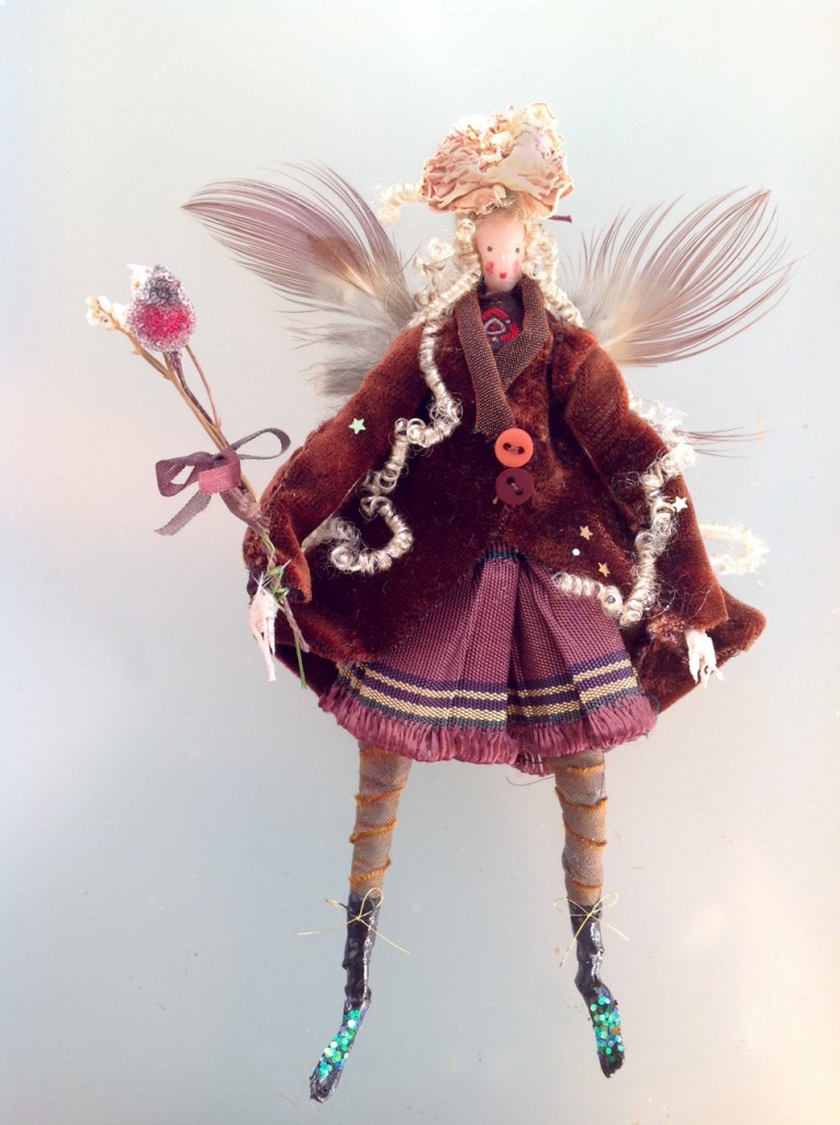 WINTER BERRY A 16cm high fairy wearing a silk velvet coat with a pleated and fringed skirt . She has pheasant feather wings , a dried rose hat and is holding a dried flower and crystallised berry wand. She comes with a hand-painted name tag and in an organza bag with dried flowers. £42 plus £3.50