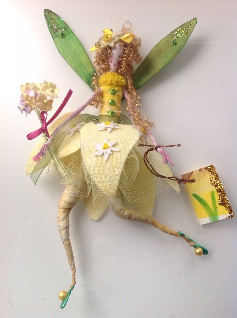 NARCISSUS A 17cm fairy with a painted silk head. This Spring fairy is wearing a plant dyed silk top with a knitted collar. Her skirt is made of Hyacinth dyed muslin embellished with little fabric flowers , all held up with a stiff net underskirt. She has paper wings and bouquet , a vintage narcissus flower in her hair and she has a hand painted name tag. She comes in an organza bag with dried daffodil heads . £30 plus £3.50 p&p