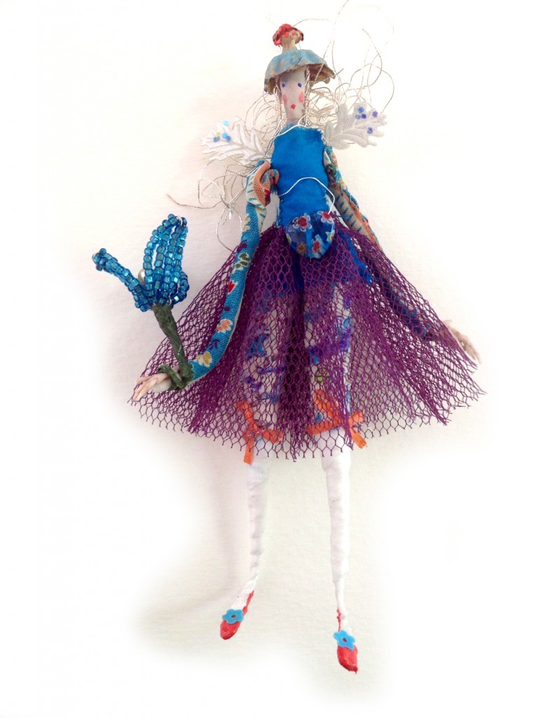 MILLY-FIORE A 12 cm high fairy wearing a Liberty print knickers with tiny fine silk ribbons, a net skirt and printed crepe de chine top, glittered wings and a Poppy seed head hat. She is holding a glass beaded flower wand. Milly comes in a15cm long wooden box decorated with pressed flowers from my cottage garden. £40 plus £3.50 postage