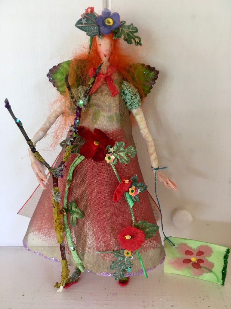 MAY- RED A 13cm high fairy with a silk painted face. This little Spring fairy is wearing a vintage cotton crochet top overlaid with a shot organza dress with a glittered hem. She has a paper and fabric flower garland embellished with sequins , an organza bow at her back and is holding a glittered twig. She comes with a hand painted name tag and in an organza bag. £35 including UK postage.